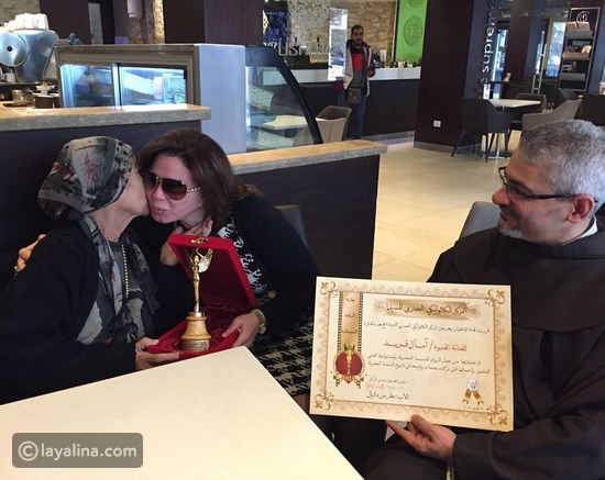 لحظة تسلم آمال فريد الدرع التكريمي من إلهام شاهين